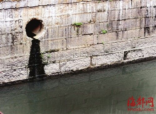 內(nèi)河一處排污口，正在流出墨黑色污水。