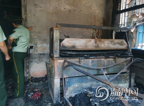 該民房右側(cè)有一臺(tái)壓模機(jī)，地上有布料殘片